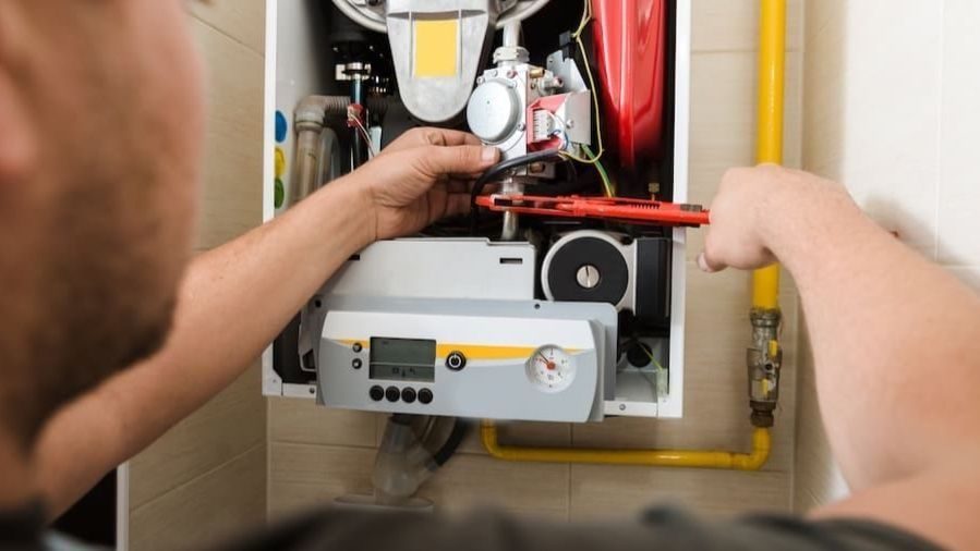 HVAC tech repairing furnace.
