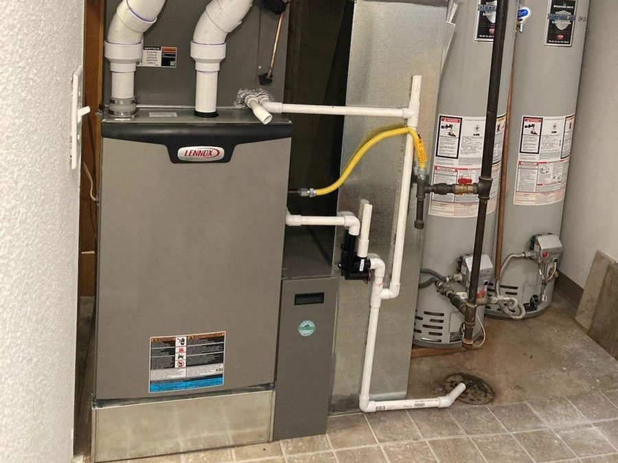 Lennox furnace and two water heaters installed in a residential utility room.